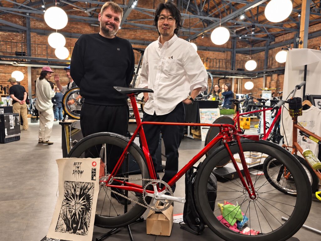 Dominic Dominiak poses with Shin-Ichi Konno, and the Project D award-winning bicycle